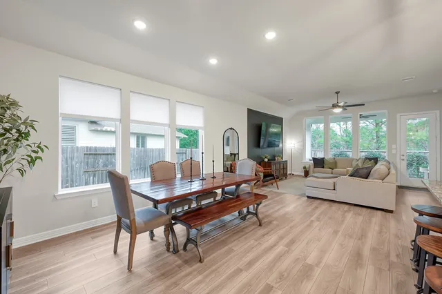 a view of a dining room and livingroom with furniture wooden floor a chandelier