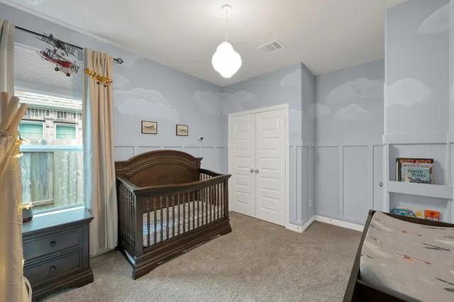a living room with a baby crib furniture and a wooden floor
