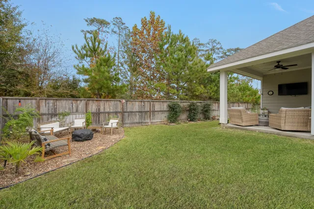 a view of a patio with couches chairs and a table and chairs with wooden fence