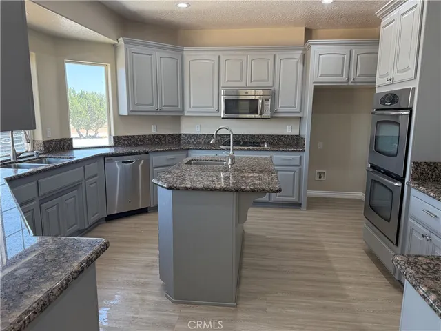 a kitchen with stainless steel appliances granite countertop a sink stove and cabinets
