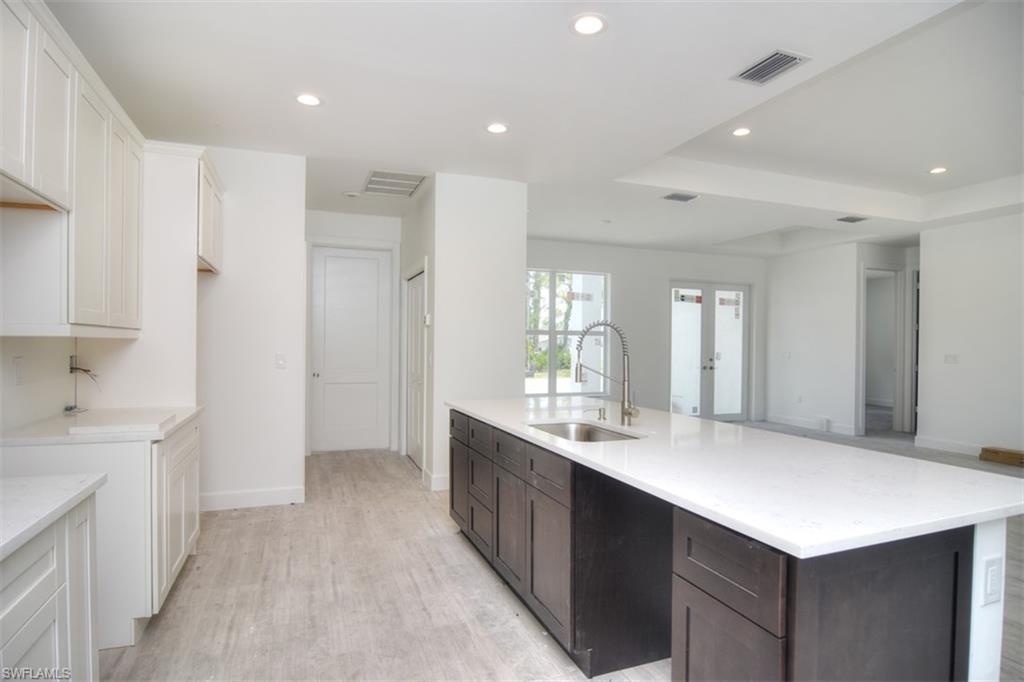 18412 Fuchsia Road Fort Myers, FL 33967 - Photo 11 of 23 a large white kitchen with a sink and dishwasher with a kitchen island
