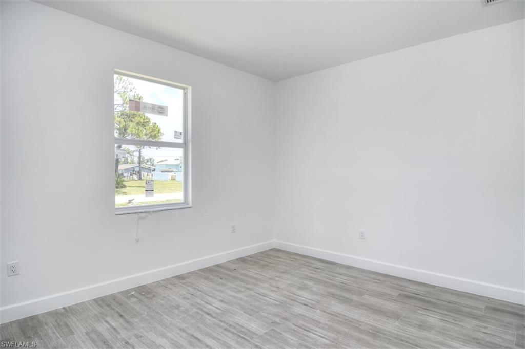 18412 Fuchsia Road Fort Myers, FL 33967 - Photo 14 of 23 an empty room with wooden floor and windows