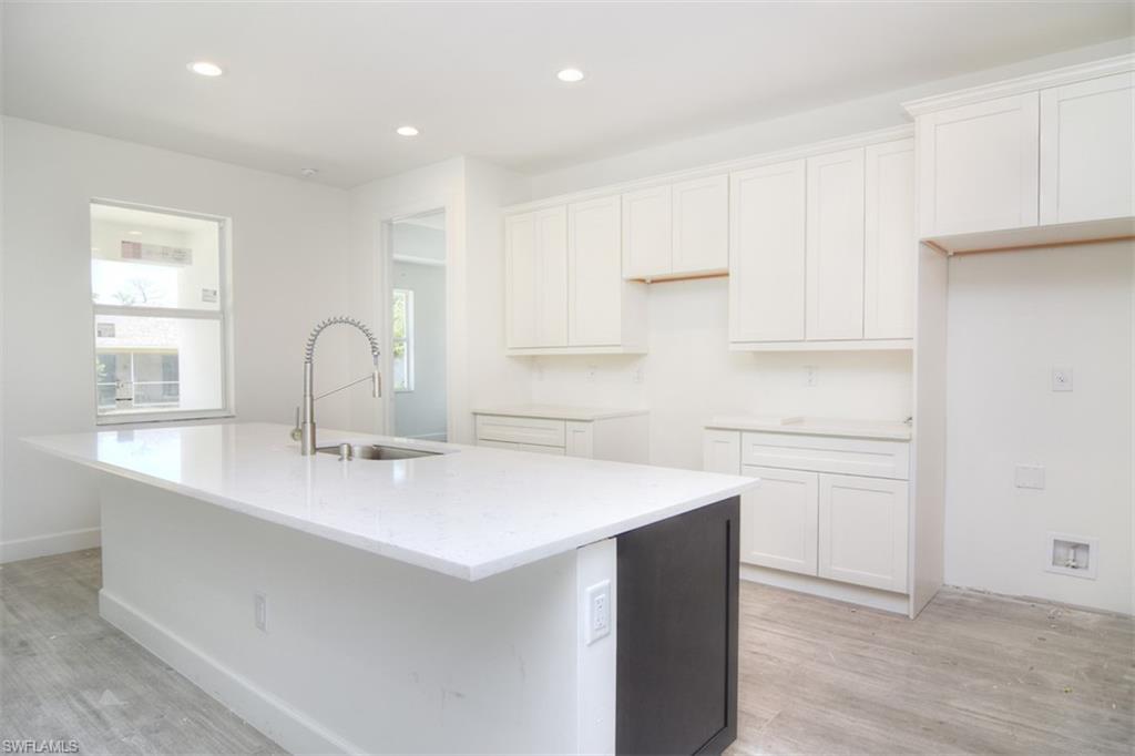 18412 Fuchsia Road Fort Myers, FL 33967 - Photo 9 of 23 a kitchen with a sink a stove a refrigerator and cabinets