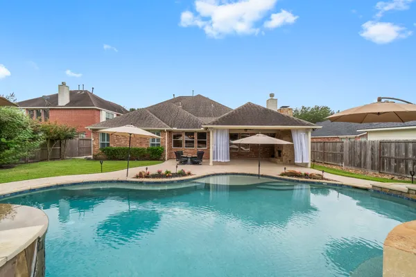 a view of a house with swimming pool and a yard