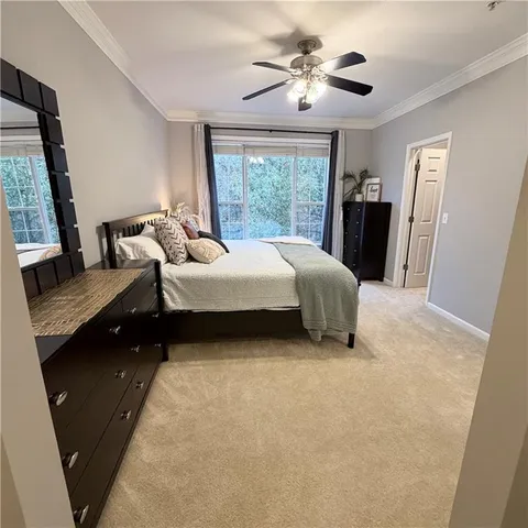 a bedroom with a bed and a flat tv screen on dresser
