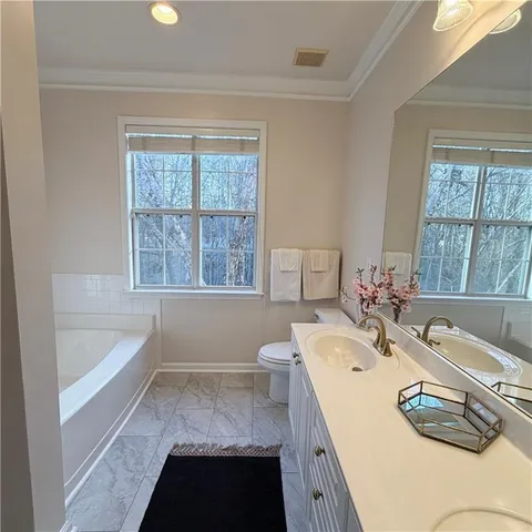 a bathroom with a tub sink and mirror