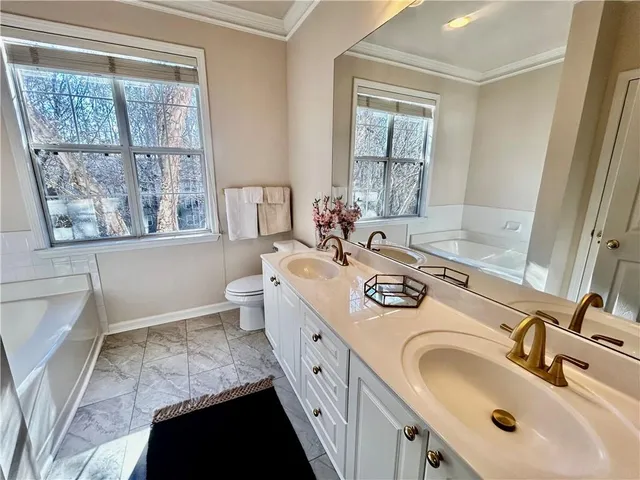 a bathroom with a double vanity sink a toilet and a mirror