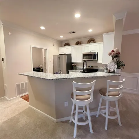 a kitchen with kitchen island granite countertop a sink and chairs