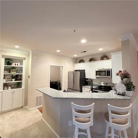 a kitchen with refrigerator and chairs