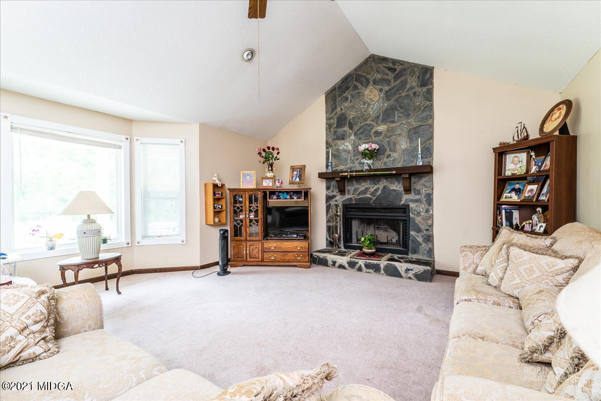 6464 Britt Road Macon, GA 31216 - Photo 2 of 10 a living room with furniture a fireplace and a large window