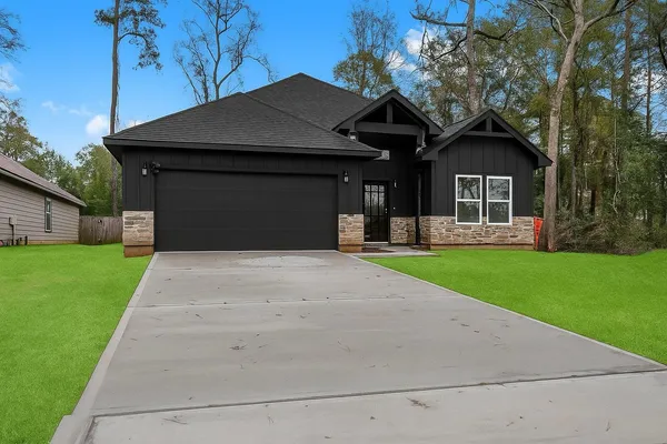 a front view of a house with a yard and trees