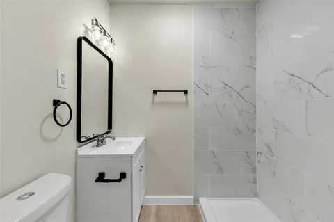 a bathroom with a sink a toilet and shower