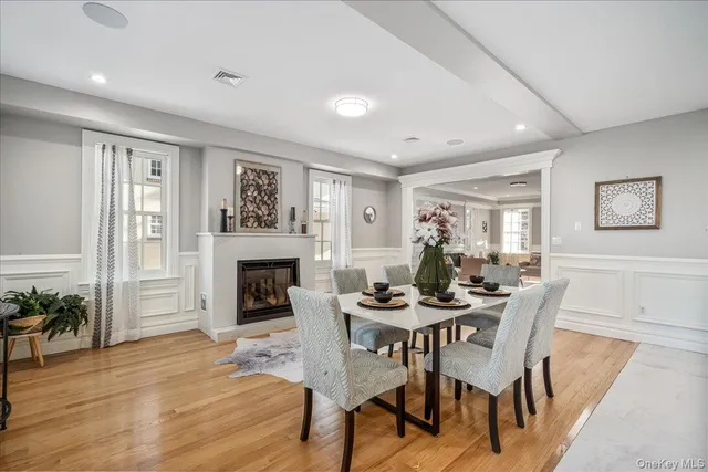 a dining room with furniture a fireplace and wooden floor