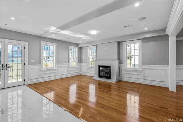 an empty room with wooden floor and fireplace