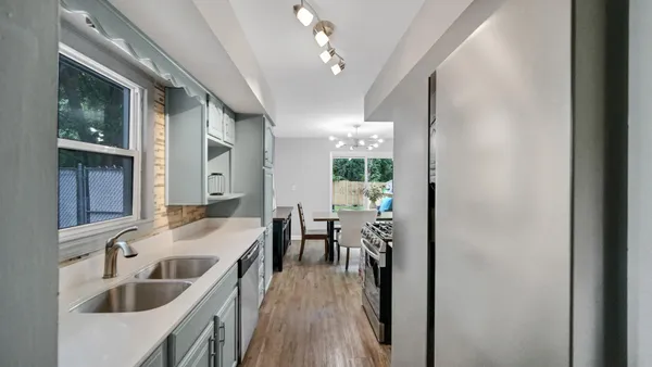 a kitchen with kitchen island a sink stove and wooden floor