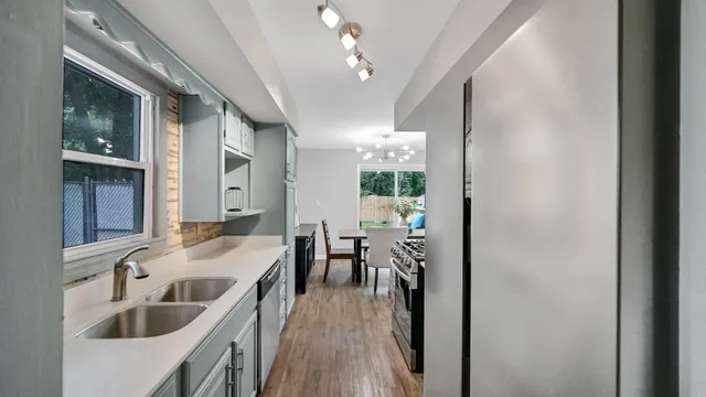 a kitchen with kitchen island a sink stove and wooden floor