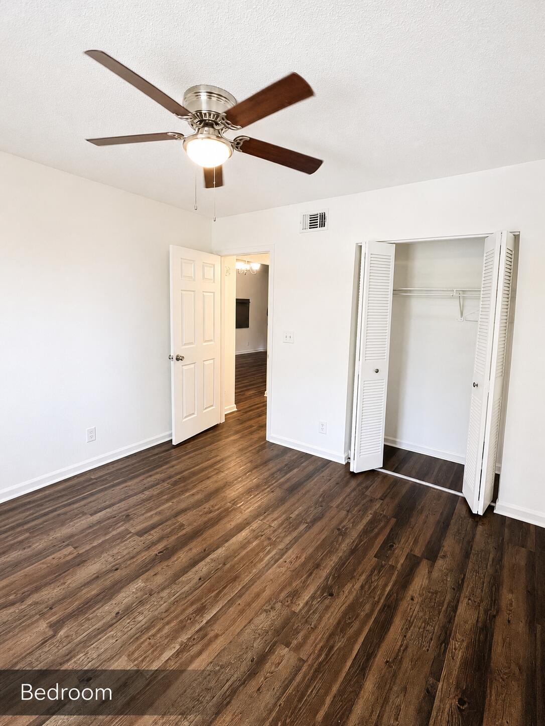 2650 Greenwood Terrace, Unit 2230 Boca Raton, FL 33431 - Photo 9 of 21 an empty room with wooden floor ceiling fan and windows