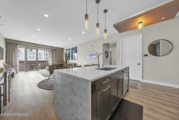 a large kitchen with stainless steel appliances kitchen island granite countertop a table chairs in it and wooden floors