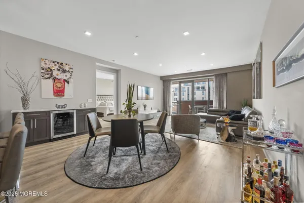 a kitchen with stainless steel appliances granite countertop a sink a refrigerator a stove a kitchen island with chairs and cabinets