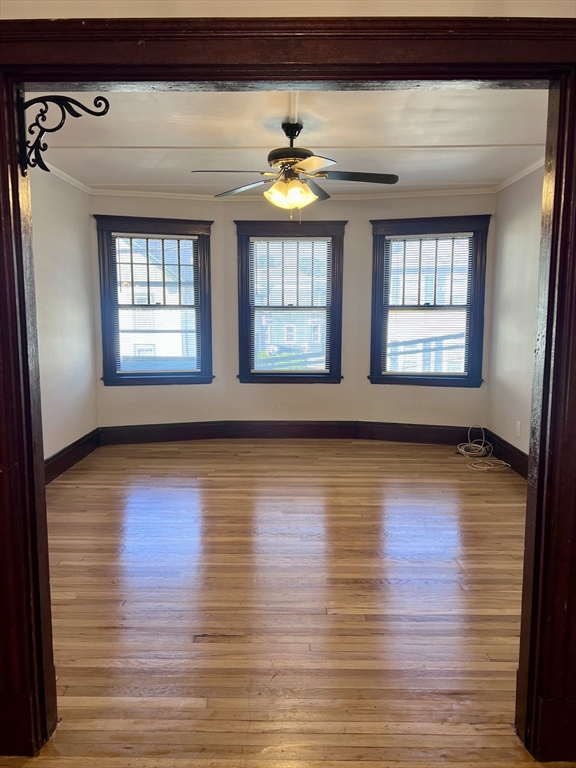 264 Boston Street, Unit 3 Lynn, MA 01904 - Photo 4 of 6 a view of an empty room with wooden floor and a window