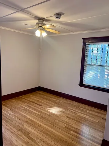 a view of empty room with window and wooden floor