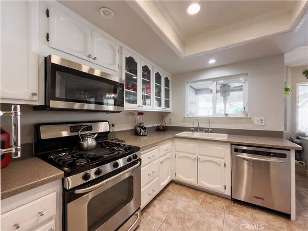 a kitchen with stainless steel appliances granite countertop a refrigerator a stove and a sink with wooden floor