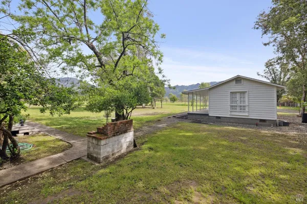 a view of a house with backyard and tree