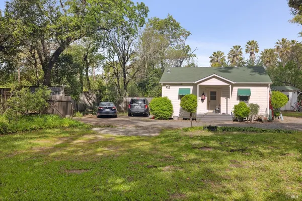 a front view of a house with a garden and yard