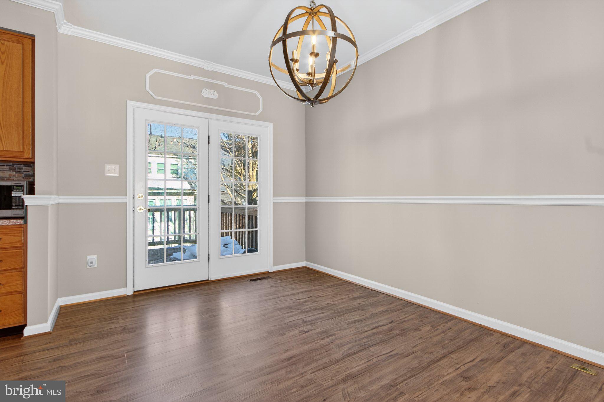 9963 Sherwood Farm Road Owings Mills, MD 21117 - Photo 13 of 48 a view of an empty room with wooden floor and a window
