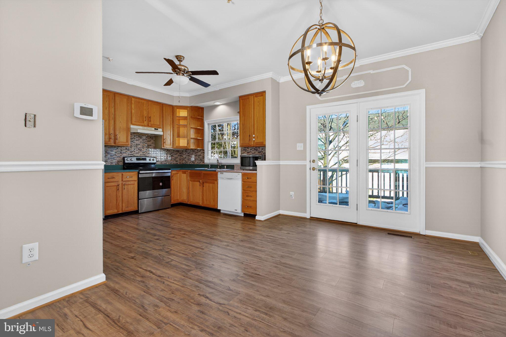 9963 Sherwood Farm Road Owings Mills, MD 21117 - Photo 15 of 48 a view of a big room with wooden floor a kitchen view and a large window
