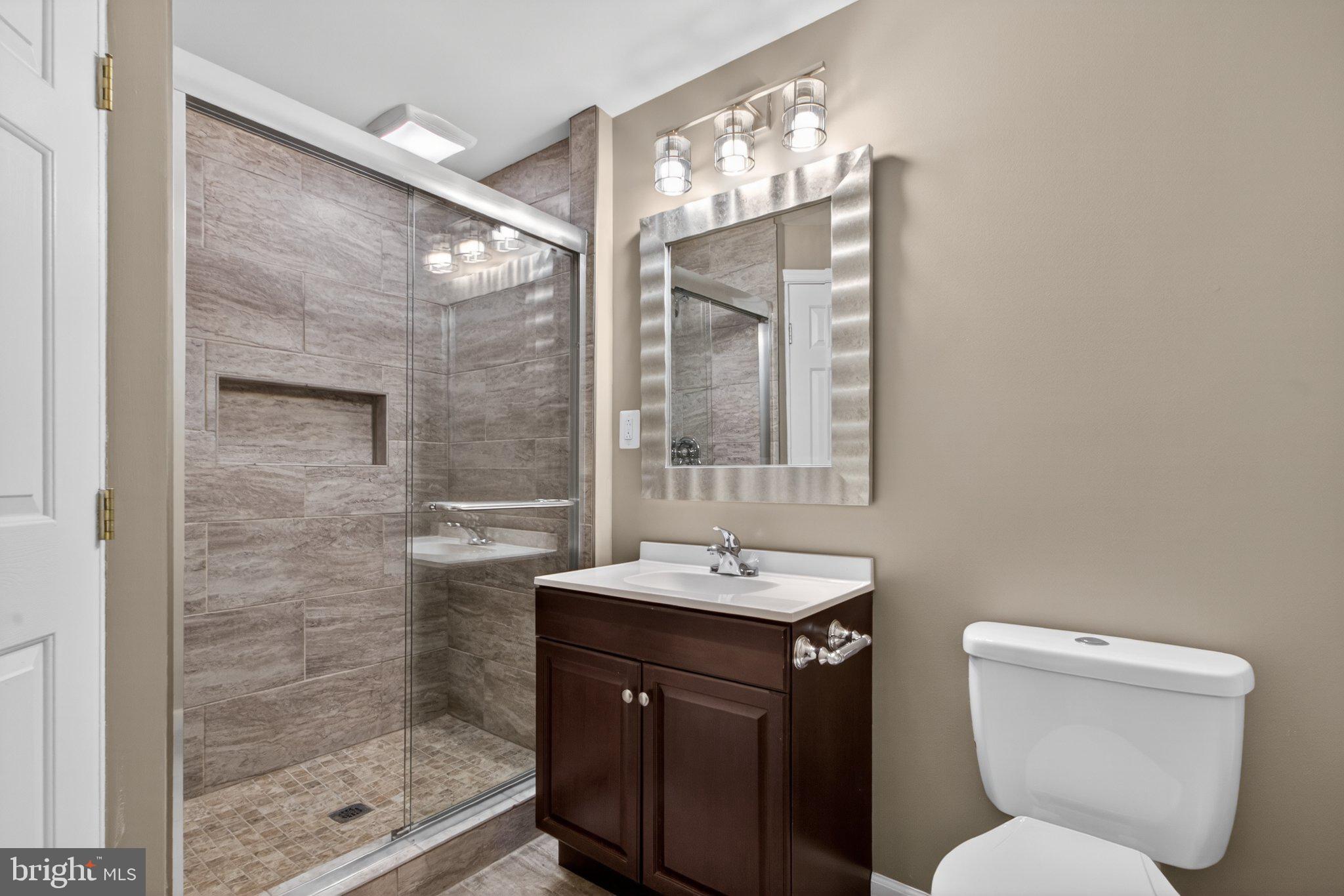 9963 Sherwood Farm Road Owings Mills, MD 21117 - Photo 31 of 48 a bathroom with a toilet sink and mirror