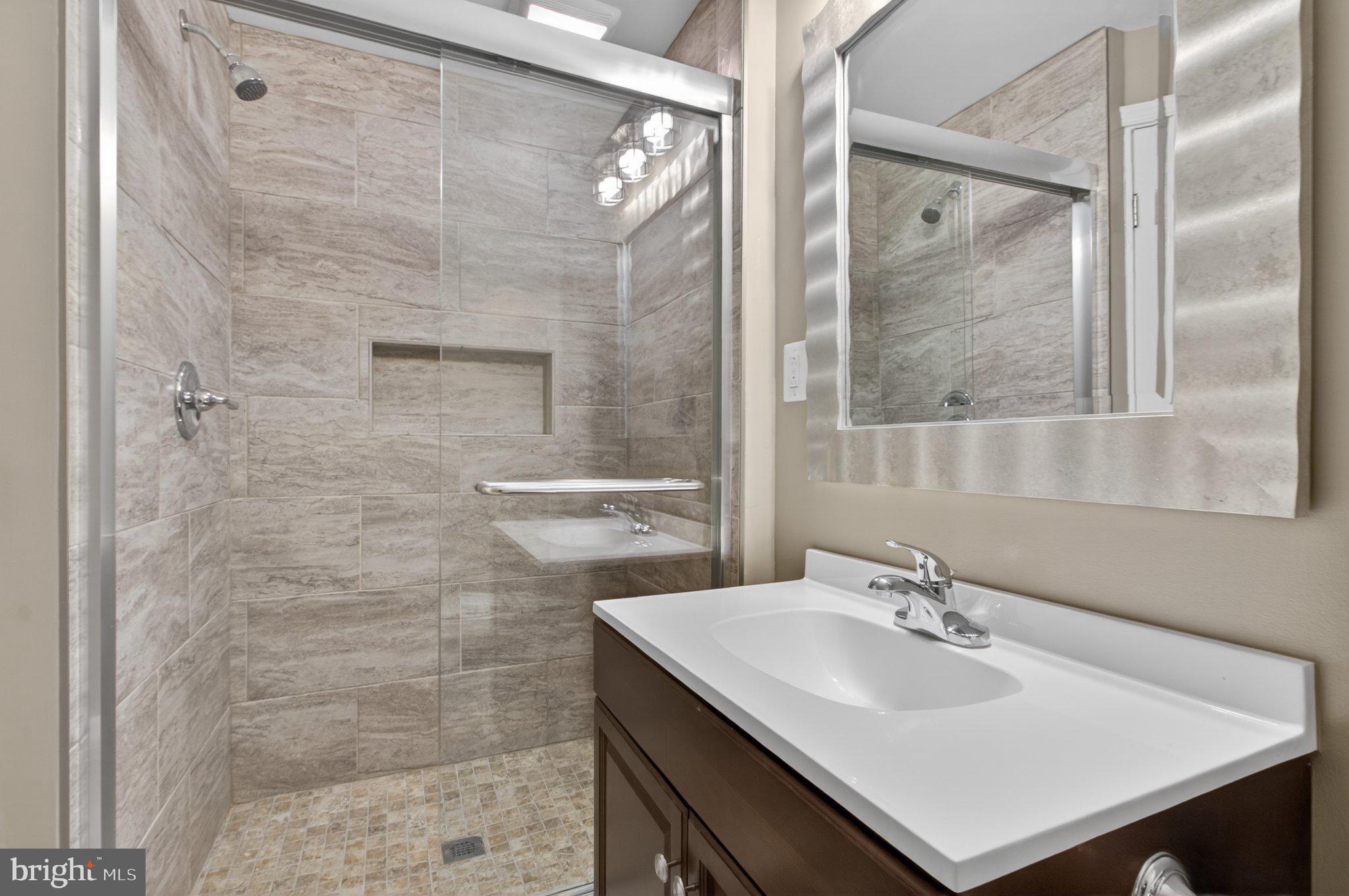 9963 Sherwood Farm Road Owings Mills, MD 21117 - Photo 32 of 48 a bathroom with a sink mirror and shower