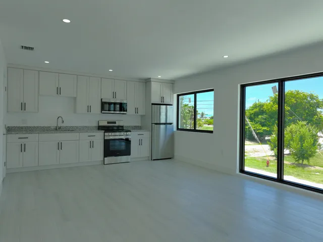 a kitchen with stainless steel appliances granite countertop a stove a sink and a refrigerator