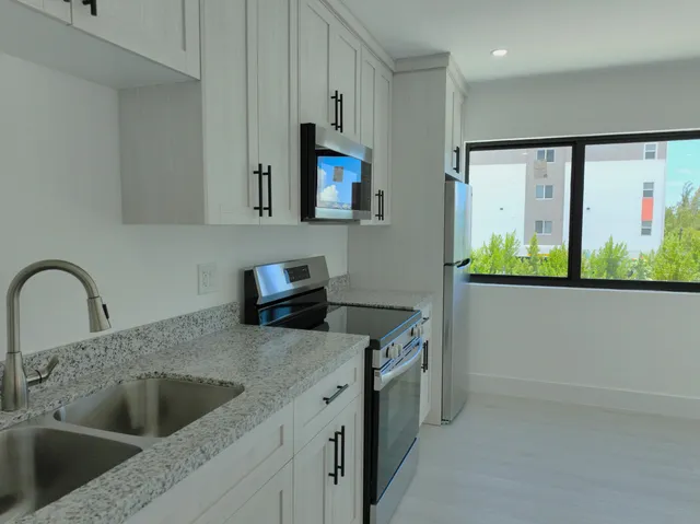 a kitchen with a stove a sink and a microwave