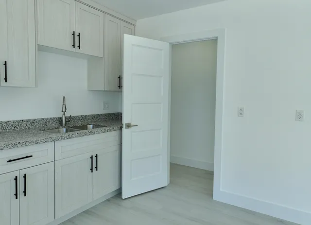 a bathroom with a granite countertop sink and white cabinets