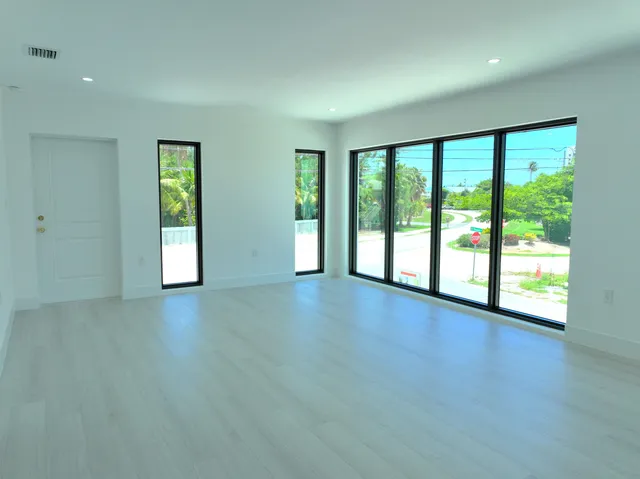 a view of an empty room with glass door and balcony