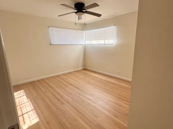 an empty room with a window and a ceiling fan