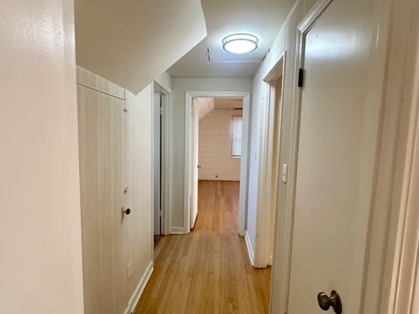 a view of a hallway with wooden floor