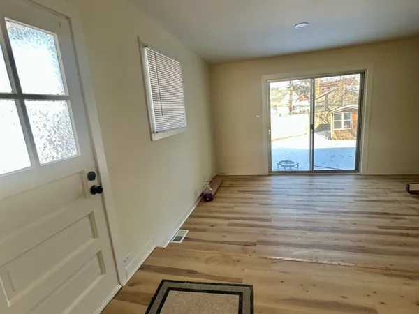 a view of an entryway with wooden floor and door
