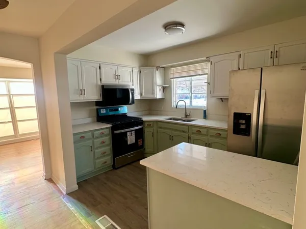 a kitchen with granite countertop a refrigerator stove top oven and sink