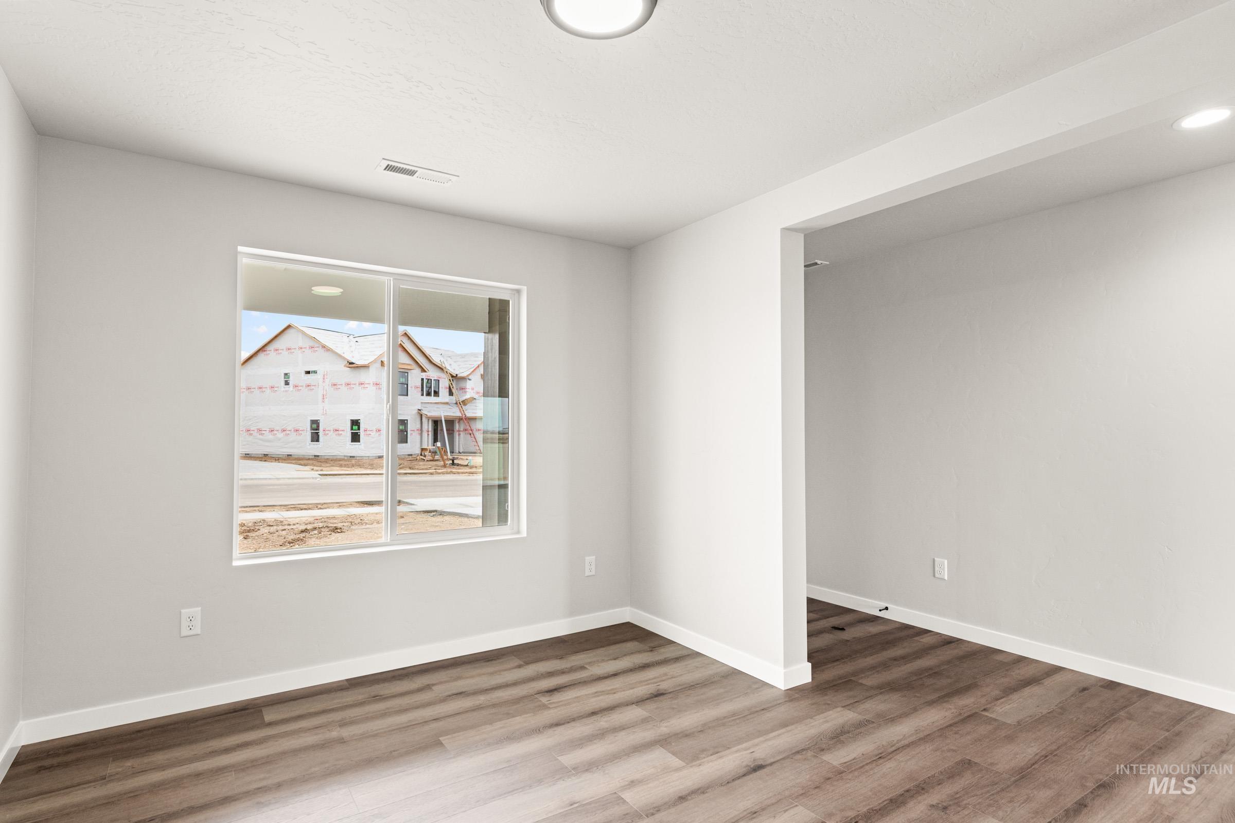 12830 Ropers Street Nampa, ID 83651 - Photo 10 of 18 Bright interior space featuring a large window, wood-finish flooring, white baseboards, and a wide entryway