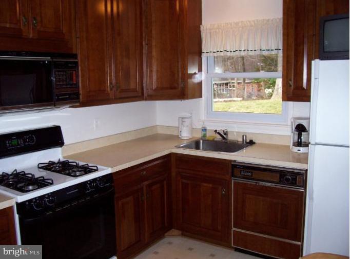 5636 Heming Avenue Springfield, VA 22151 - Photo 16 of 30 a kitchen with stainless steel appliances a stove a sink and a microwave