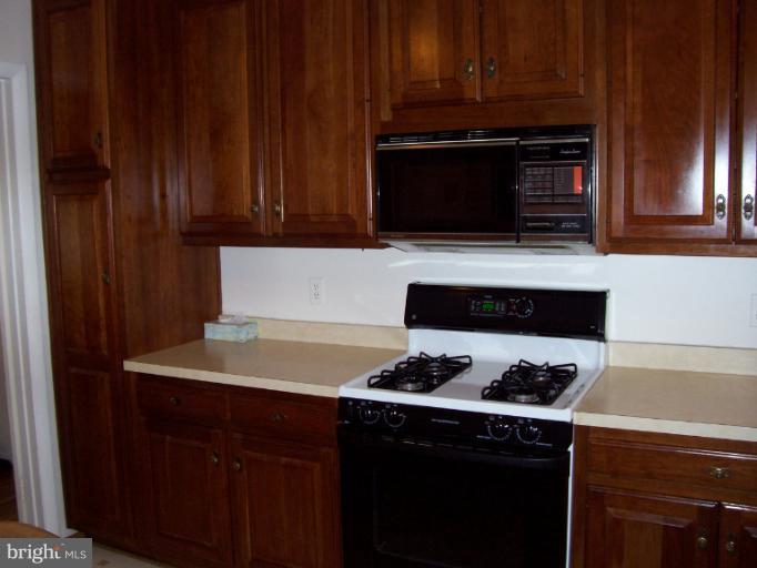 5636 Heming Avenue Springfield, VA 22151 - Photo 4 of 30 a kitchen with wooden cabinets and a stove top oven