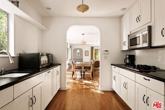 a kitchen with stainless steel appliances a stove sink microwave and cabinets