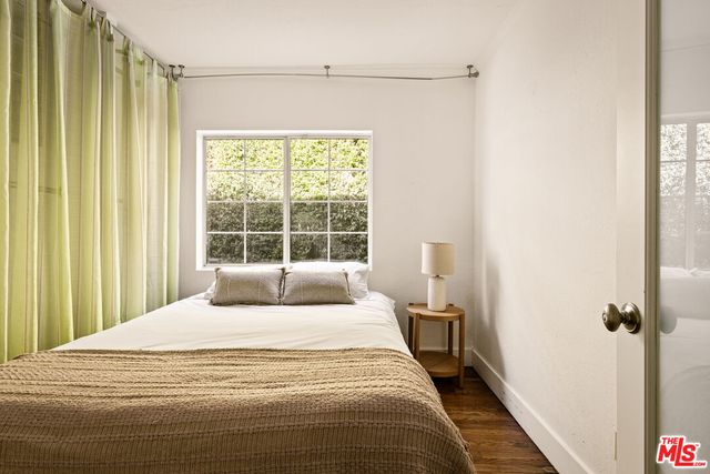 a large bed sitting in a bedroom next to a window