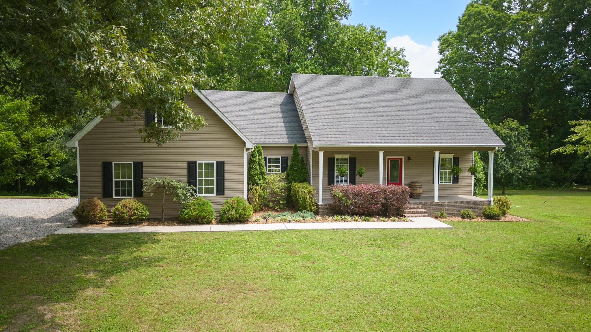 16 Shasteen Ridge Road Lynchburg, TN 37352 - Photo 1 of 55 a front view of a house with a yard and potted plants