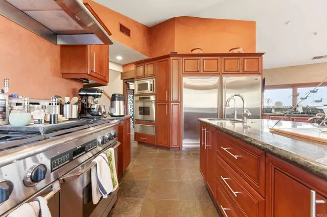 a kitchen with stainless steel appliances granite countertop a sink and a stove