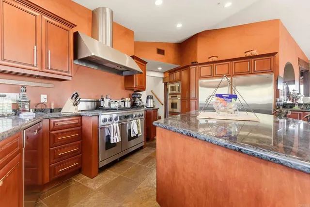a kitchen with stainless steel appliances a table and chairs in it