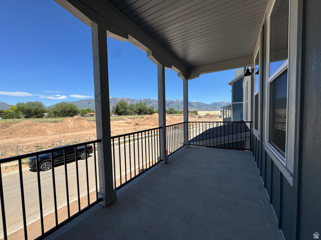 1472 North 1875 West, Unit 151 Layton, UT 84041 - Photo 9 of 20 Covered balcony featuring a concrete floor, black metal railings, and a blue exterior with white trim