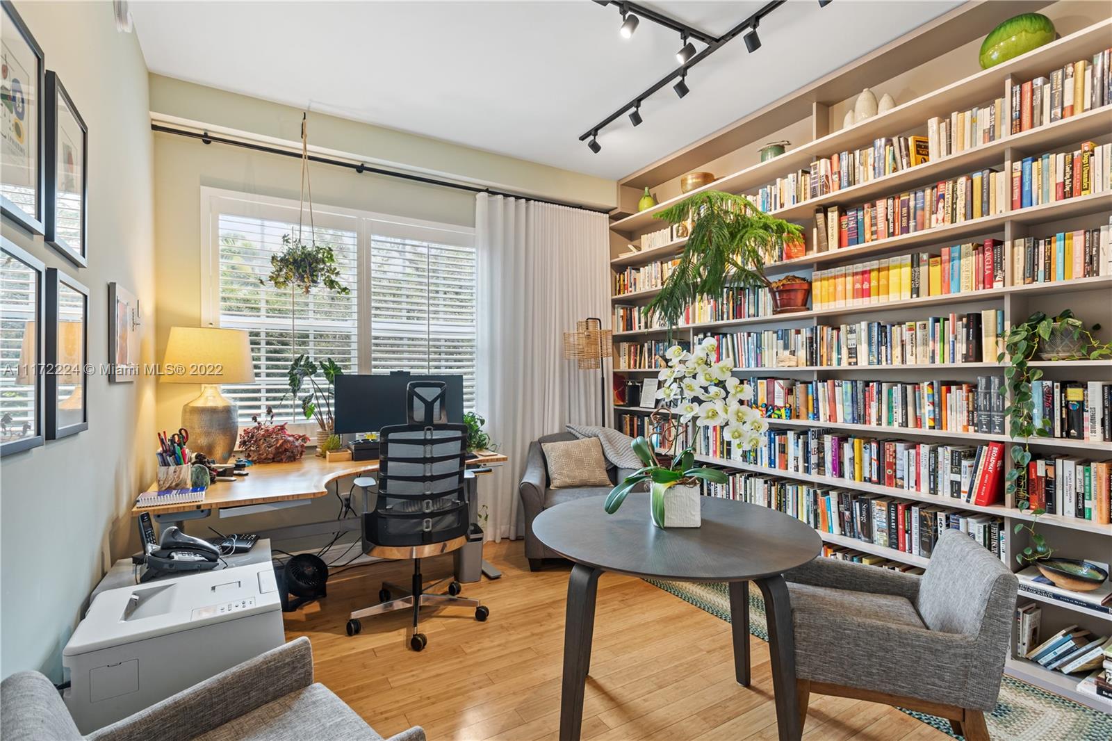 7682 Southwest 54th Avenue Miami, FL 33143 - Photo 17 of 37 a view of a workspace with furniture bookshelf and a window